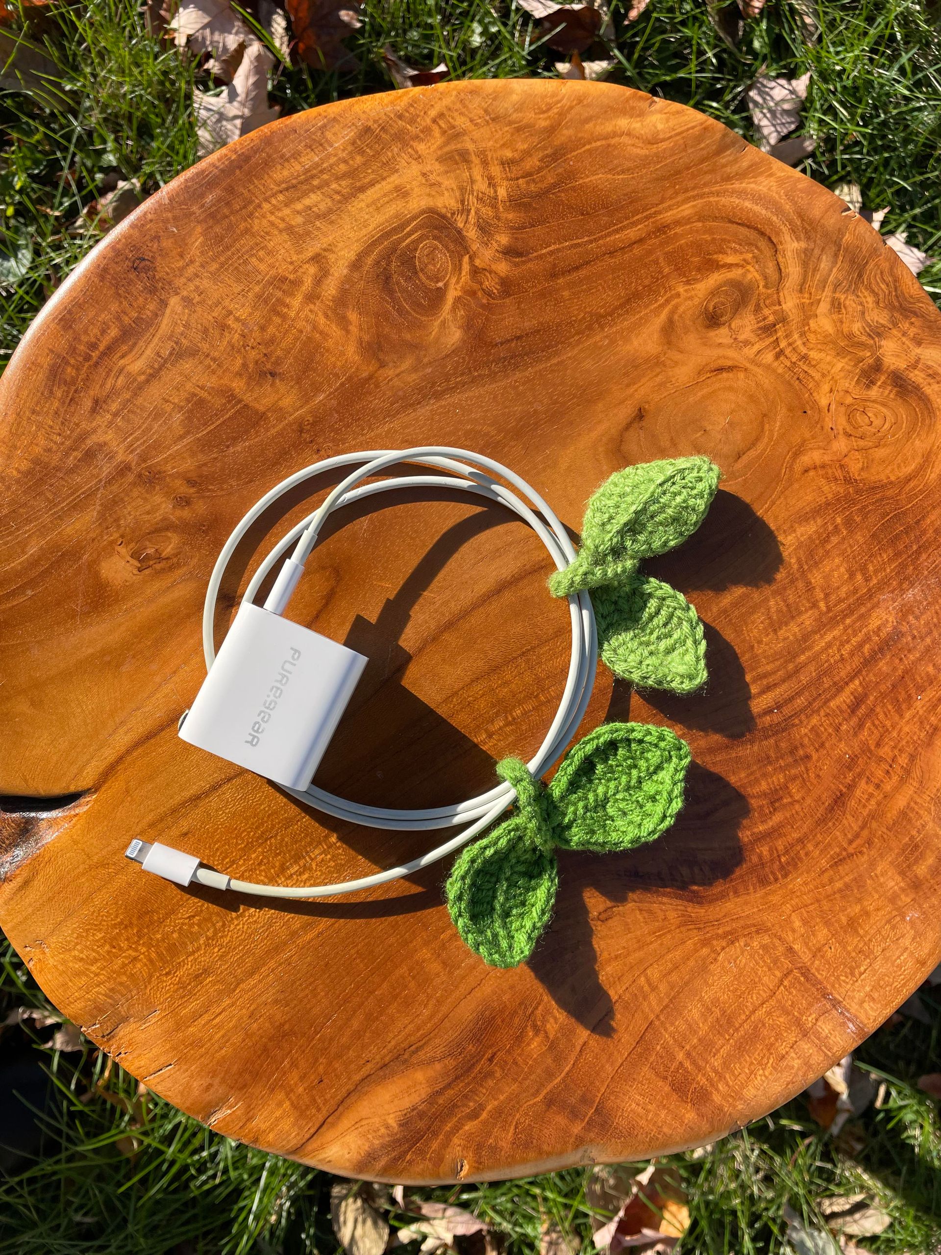 A phone charger is sitting on top of a wooden table.