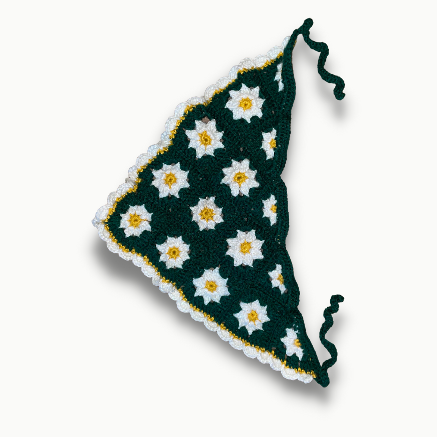 A green triangle with white and yellow daisies on it