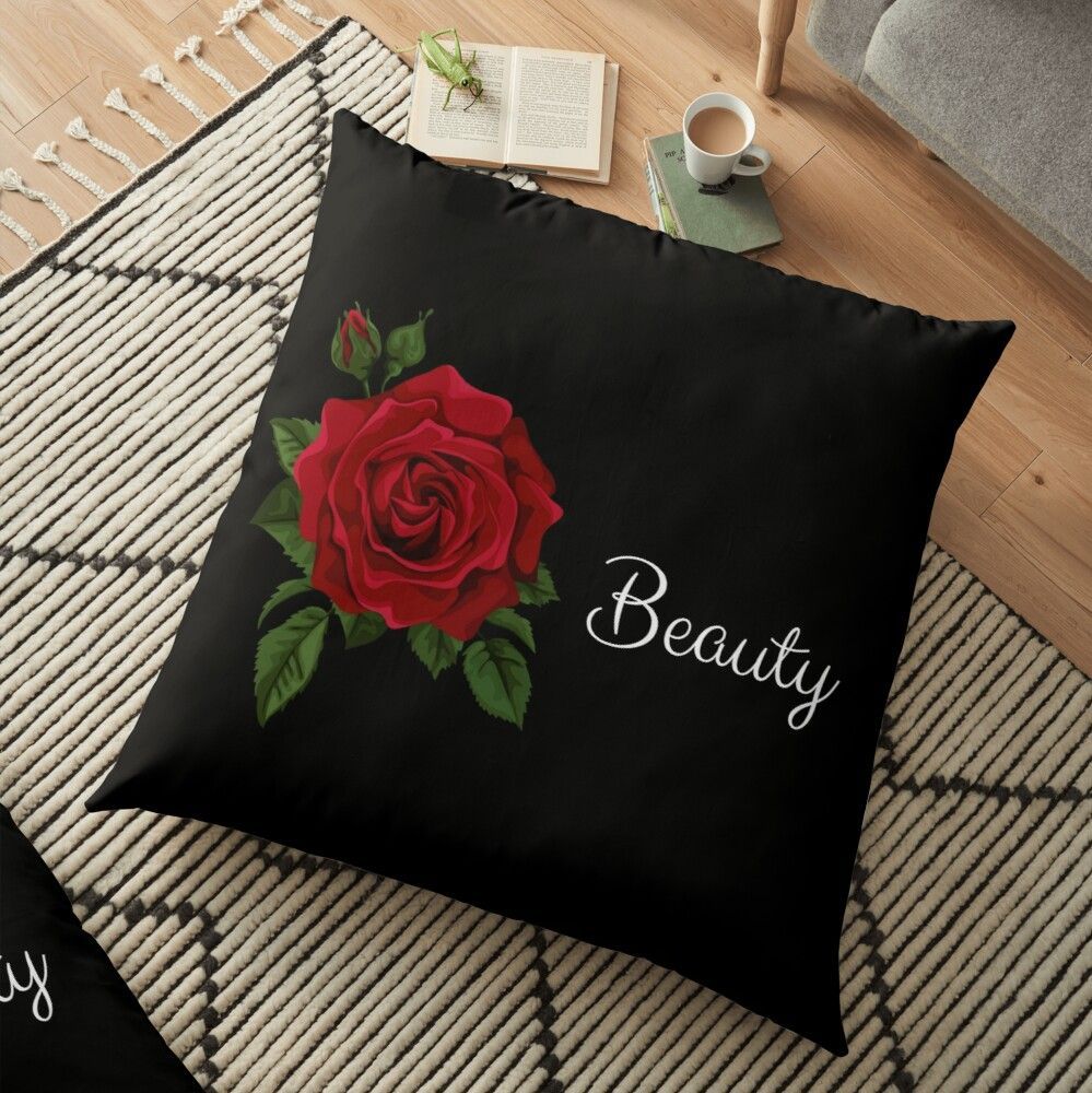 A floor pillow with a red rose and the word beauty on it