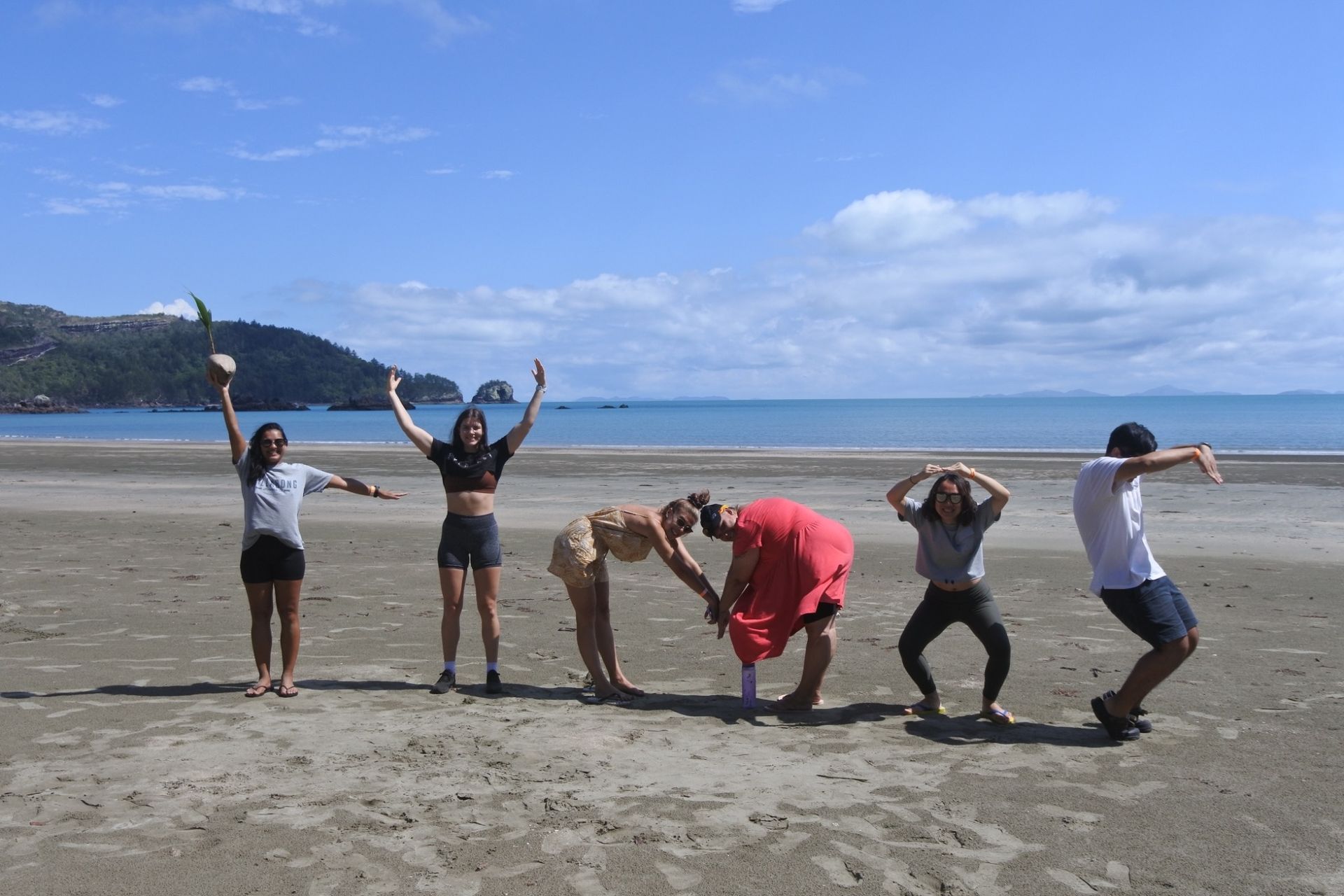 A Group of People Are Posing for a Picture on a Beach — Café and Restaurant in Whitsundays, QLD