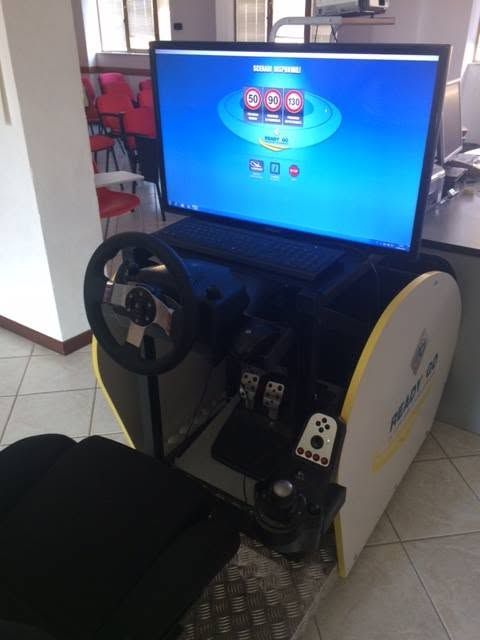Simulatore di corse arcade con volante e sedile, che mostra uno schermo di gioco in una stanza