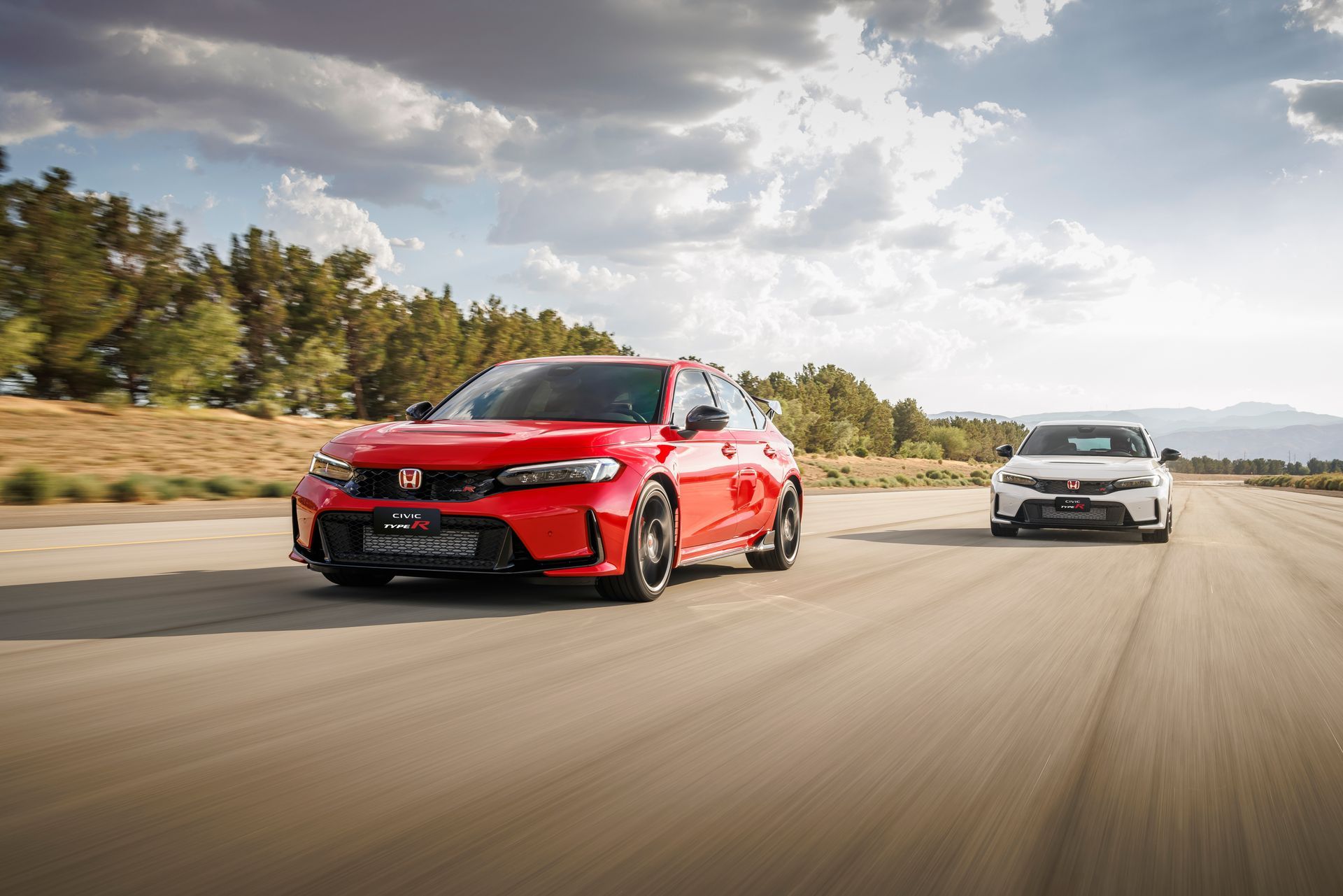 Um Honda Civic Type R vermelho trafegando em uma estrada ao lado de um carro branco sob um céu nublado.