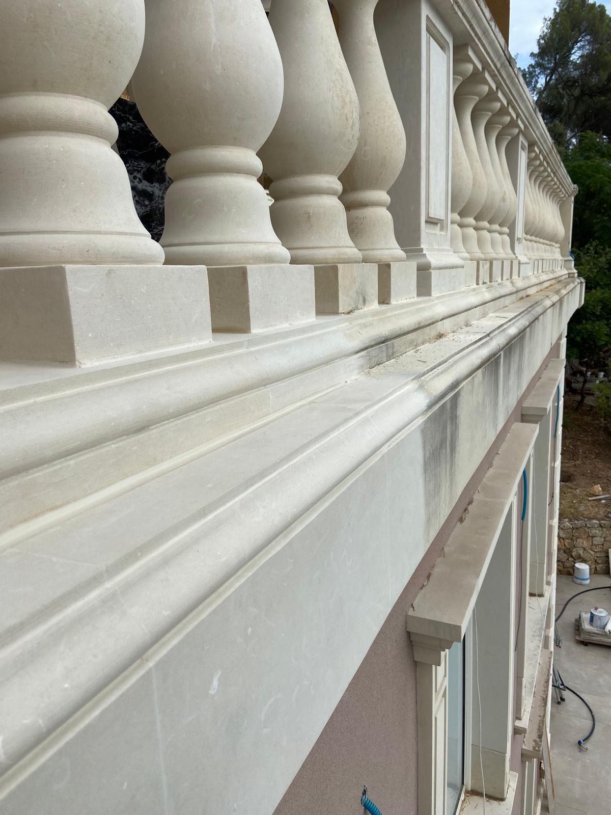 Un edificio bianco con un balcone su un lato.
