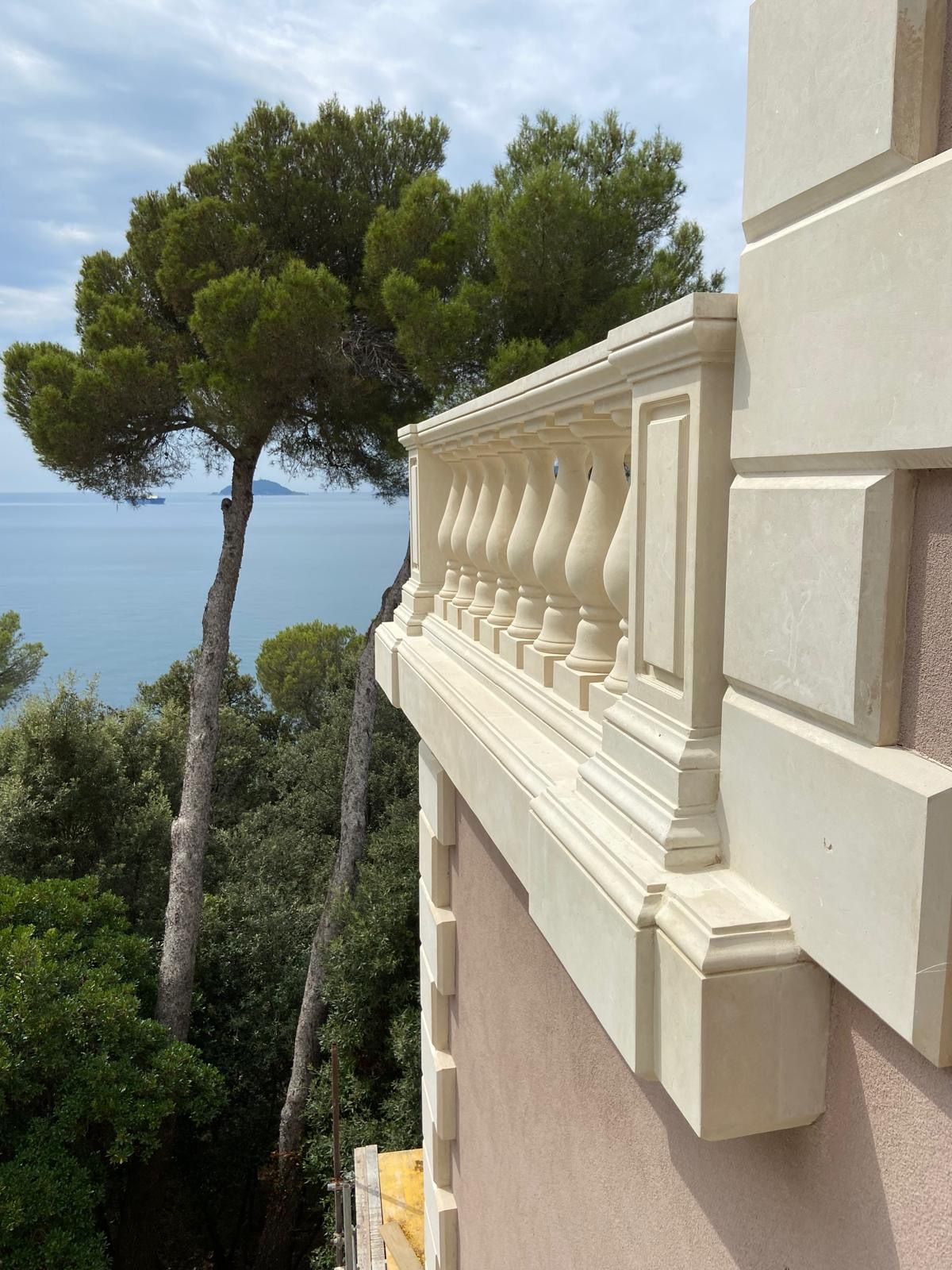 Un balcone con vista sull'oceano e sugli alberi