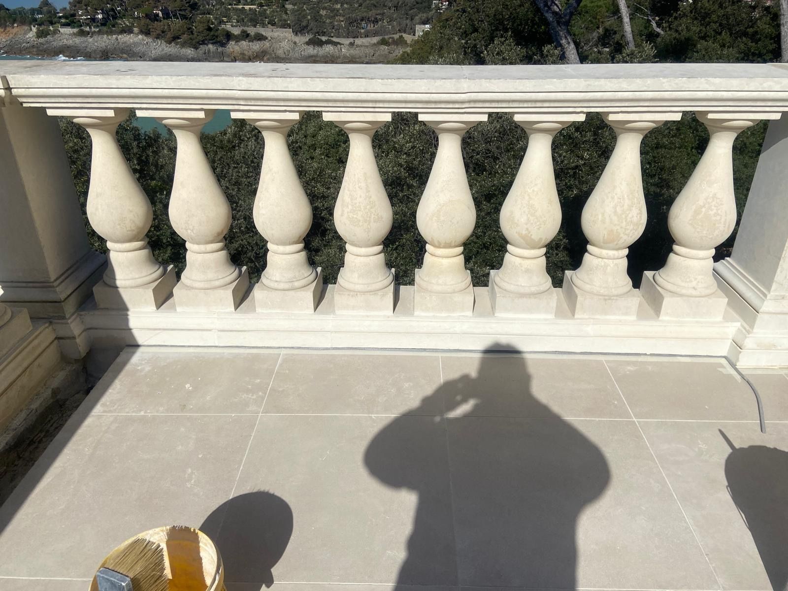 L'ombra di una persona è proiettata su un balcone con ringhiera