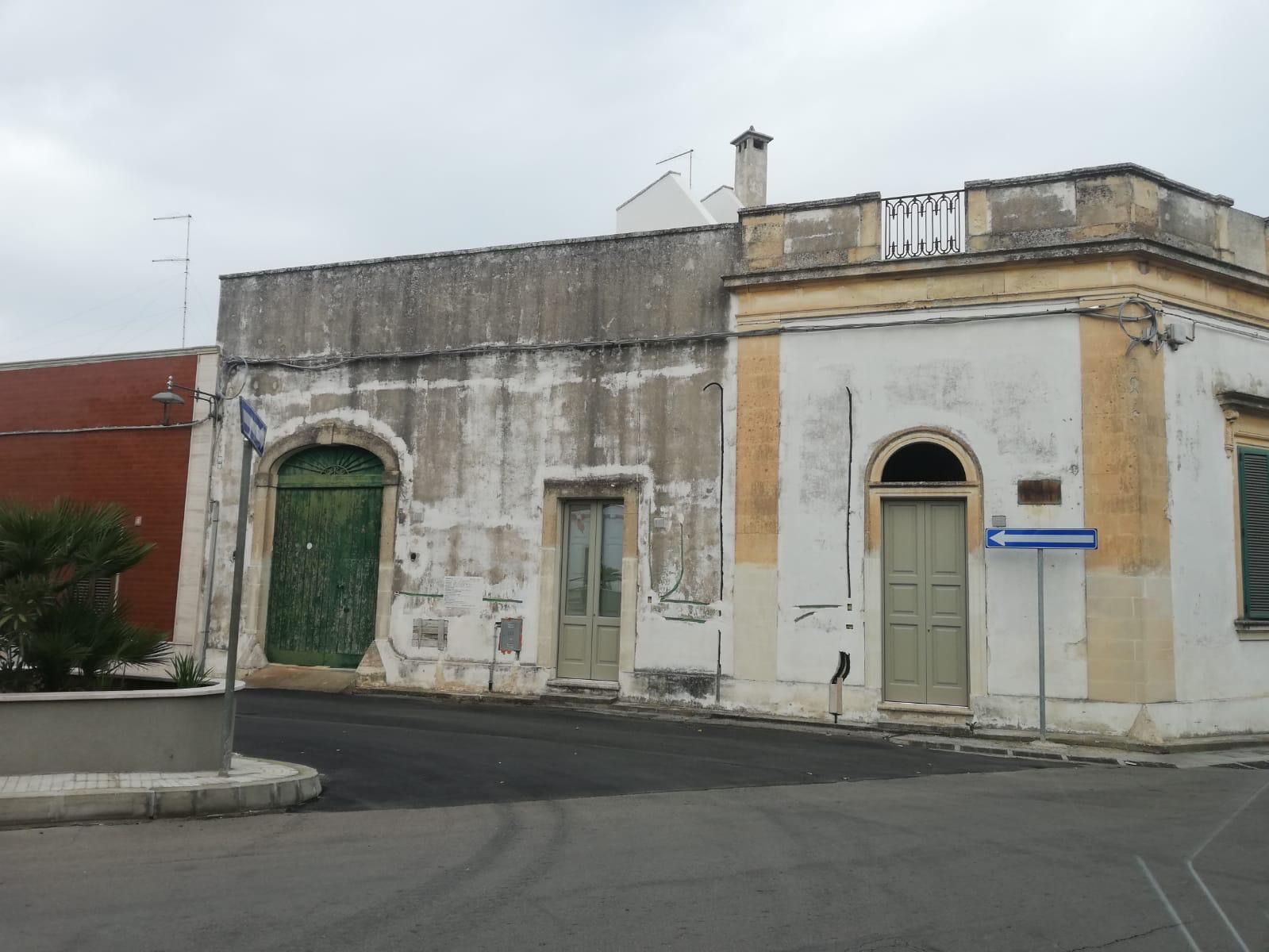 Un grande edificio con un balcone e una croce in cima