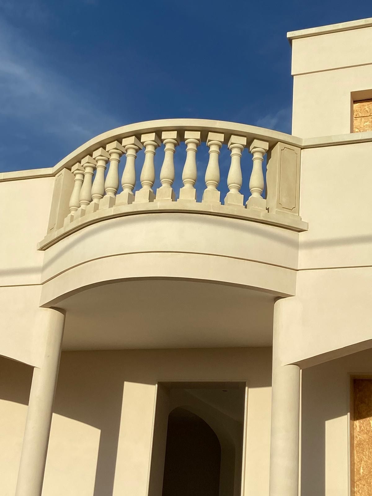 Un edificio bianco con un balcone e colonne