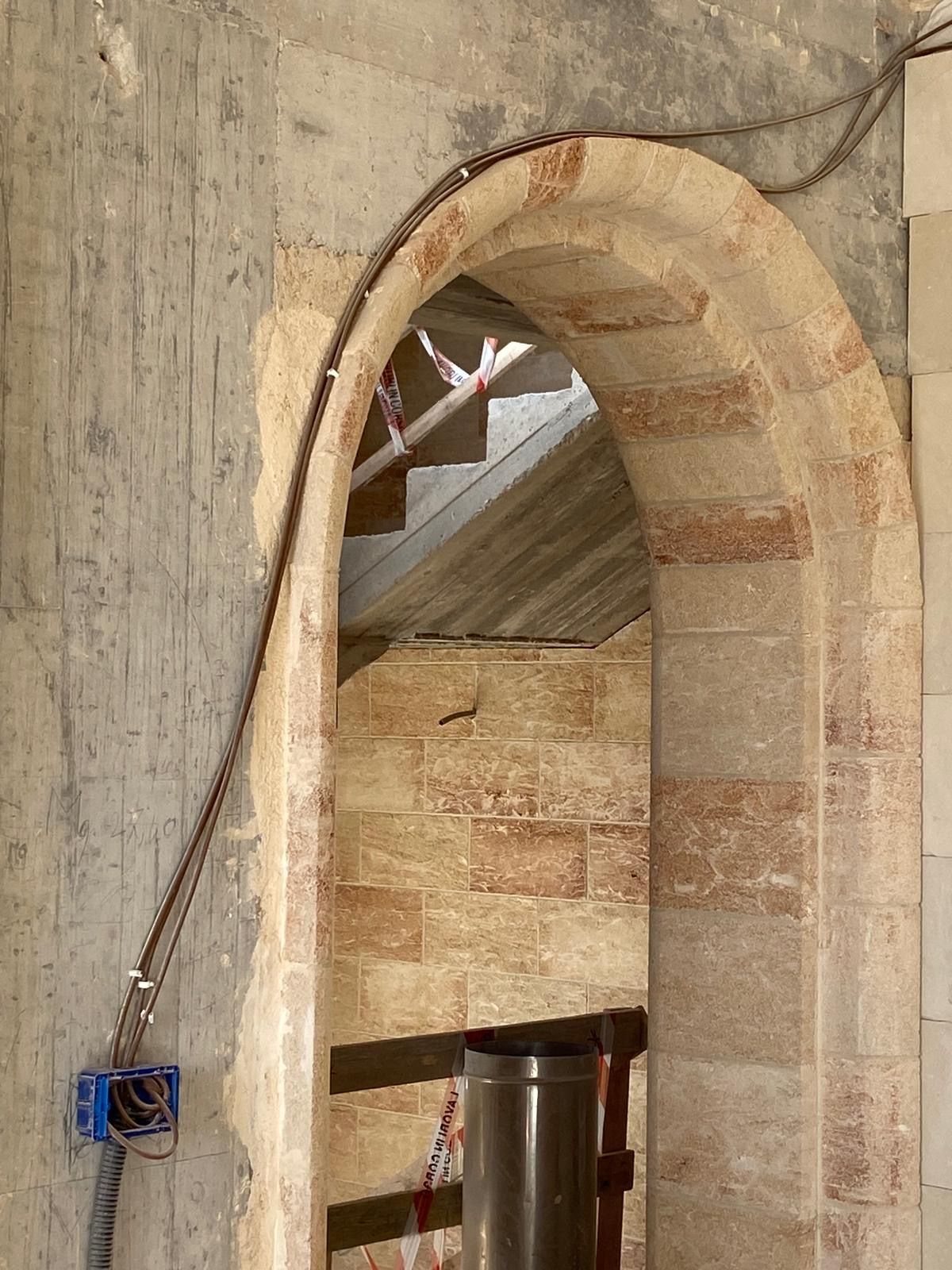 Un arco in mattoni che conduce a una scala in un edificio