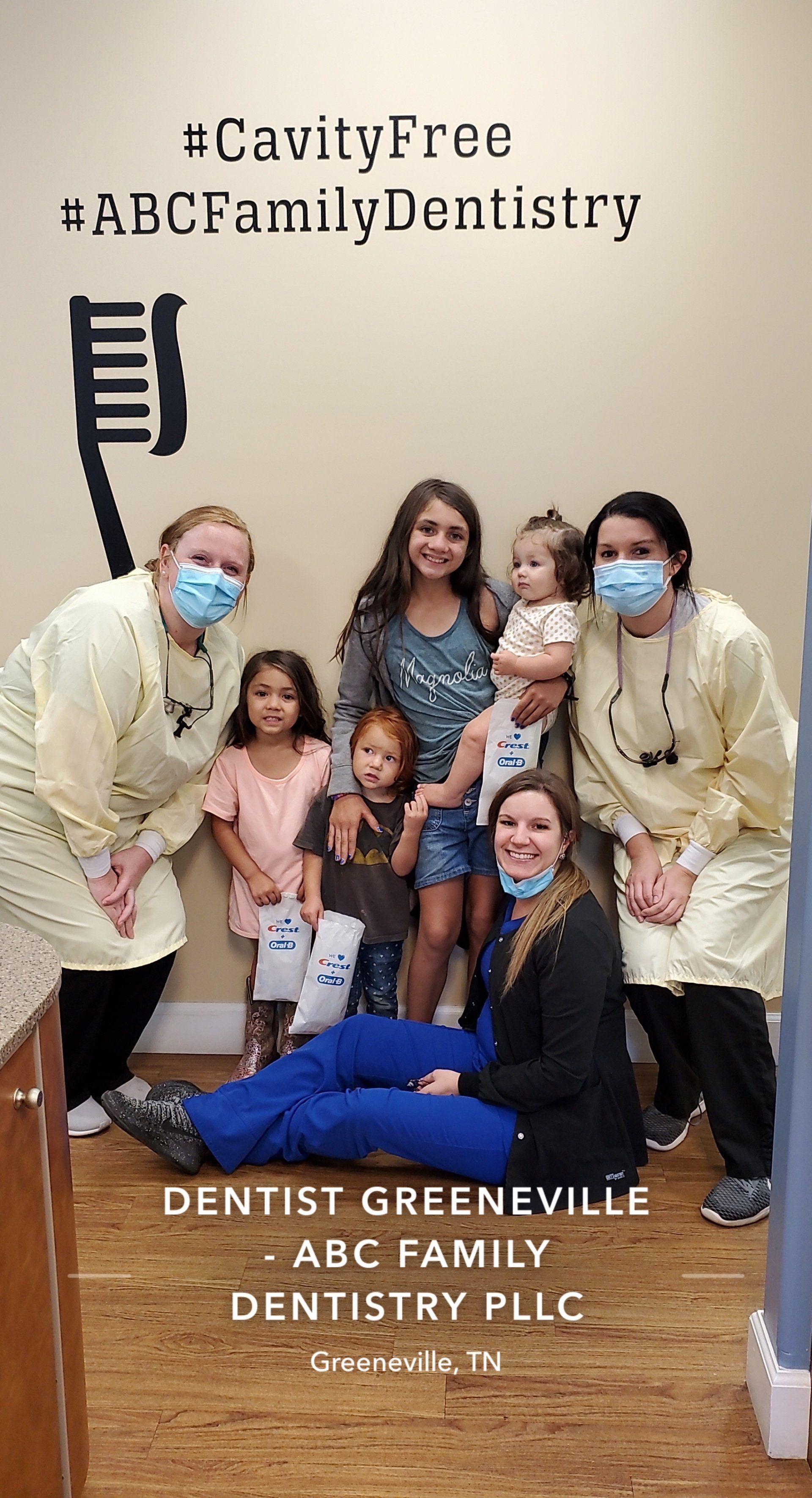 Two masked dentists and six children pose in a dental office.  #CavityFree.  ABC Family Dentistry, Greeneville, TN.