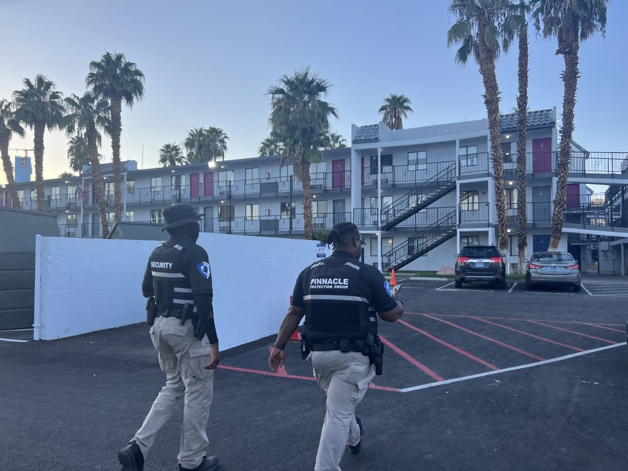 Two police officers are walking in front of a building