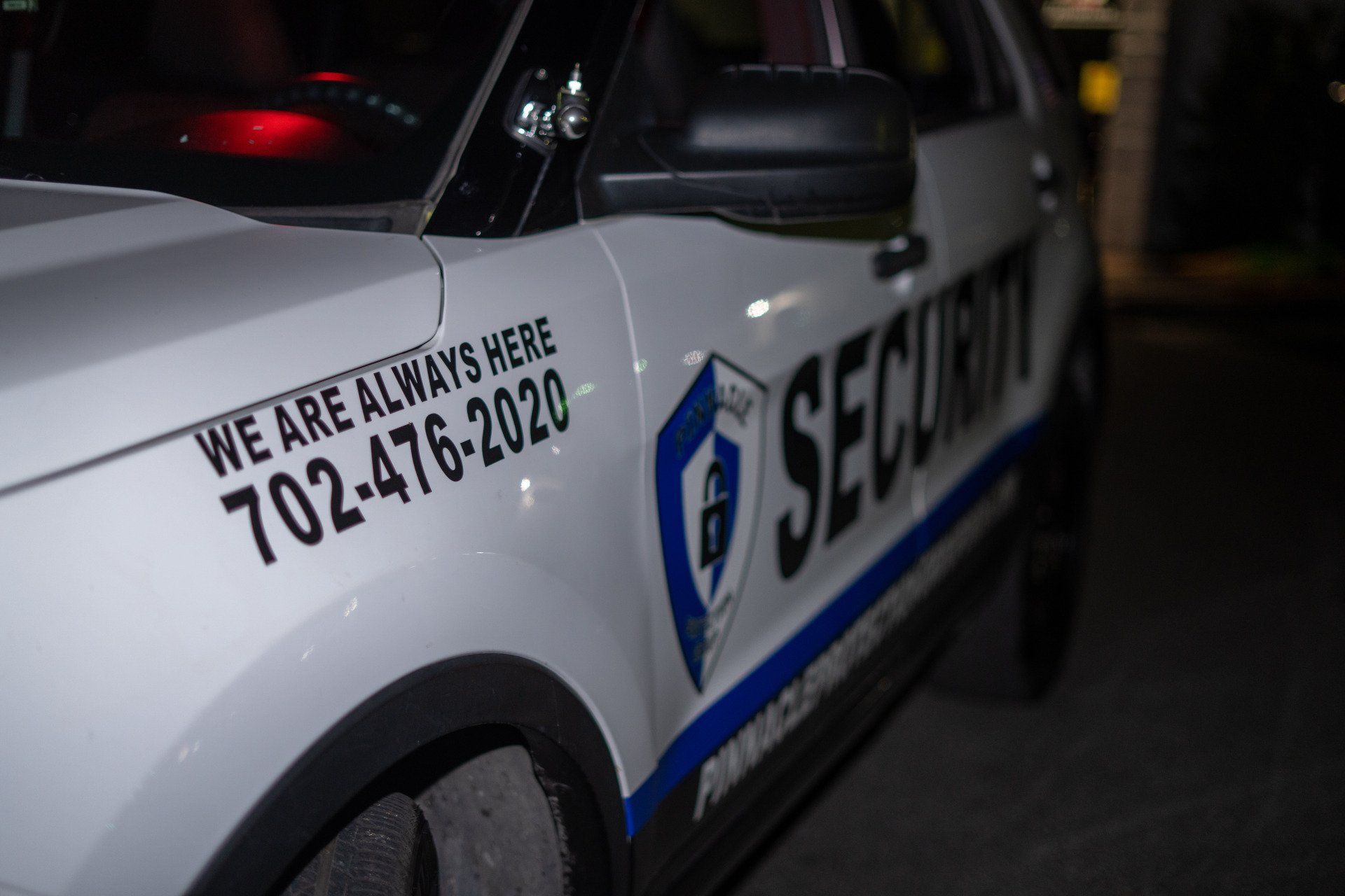 a security car is parked in a parking lot at night .