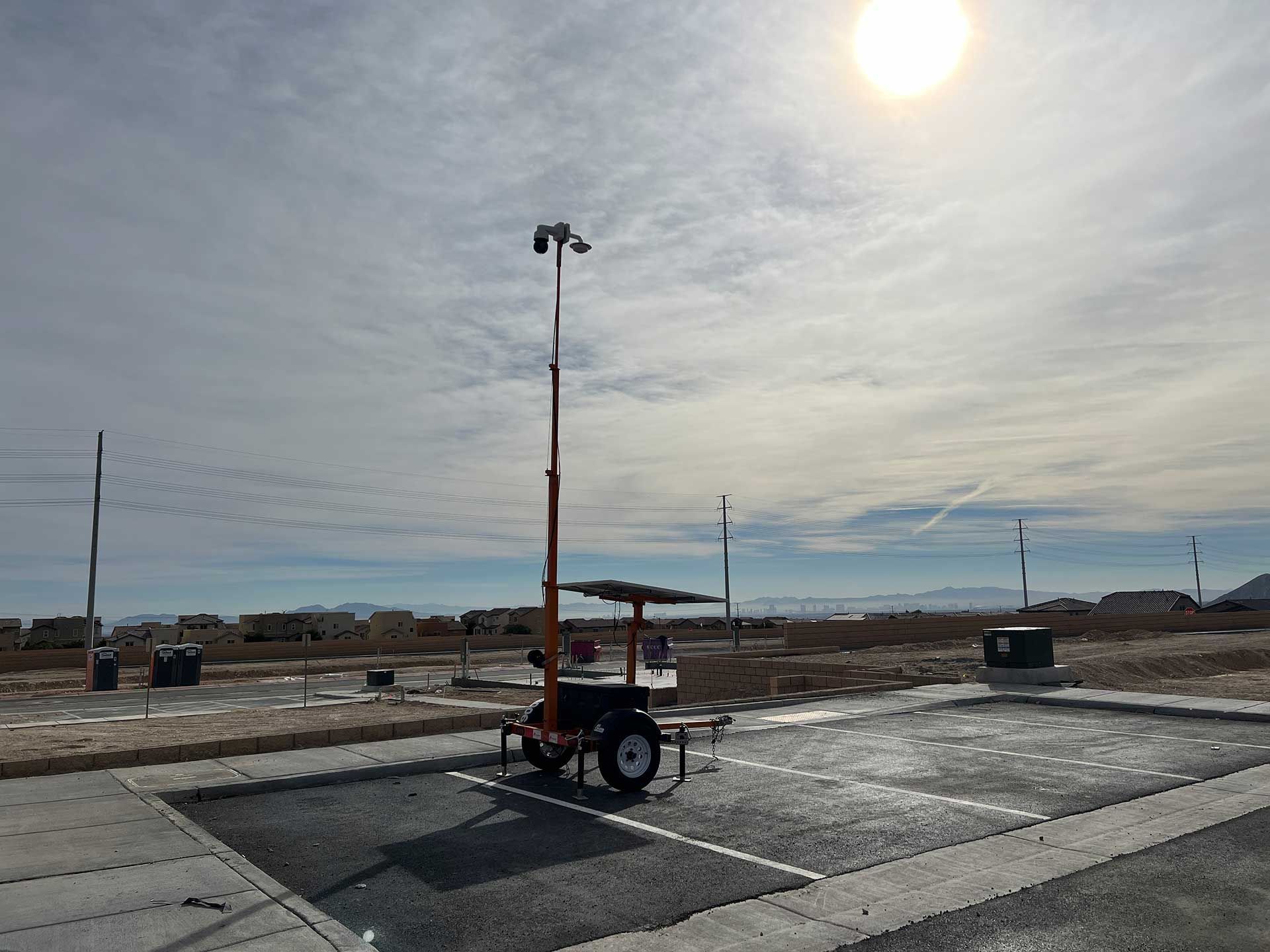 A trailer with a camera on it is parked in a parking lot.