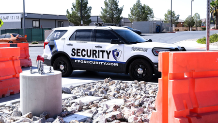 two security cars are parked in a parking lot in front of a building .