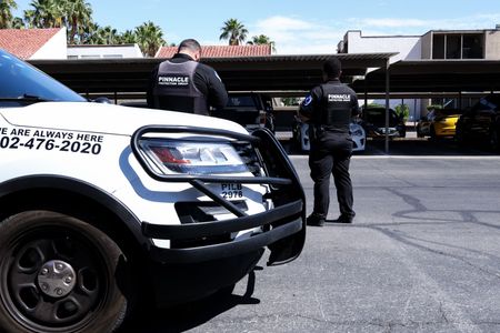 two security cars are parked in a parking lot in front of a building .