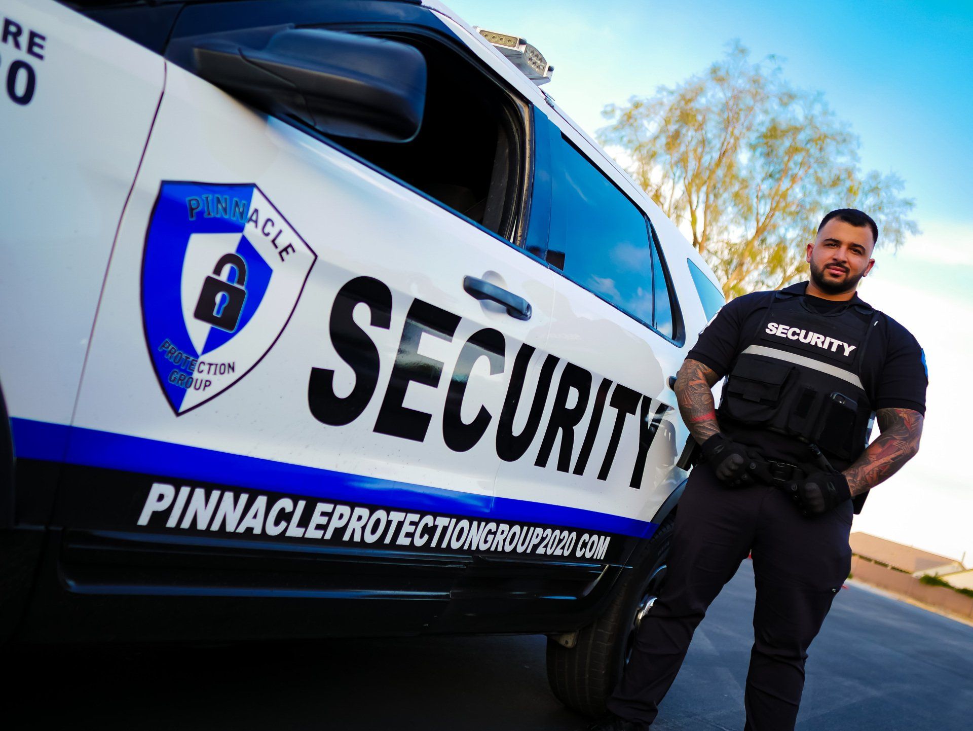 a security guard is standing next to a security vehicle .