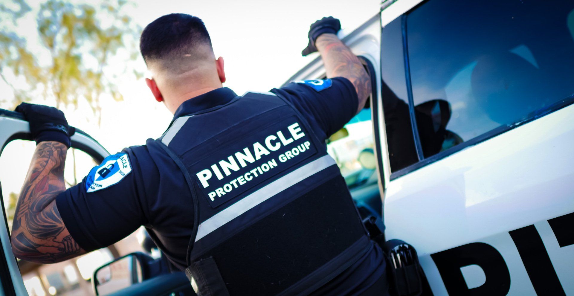 Security guard exiting a vehicle, wearing a uniform with 