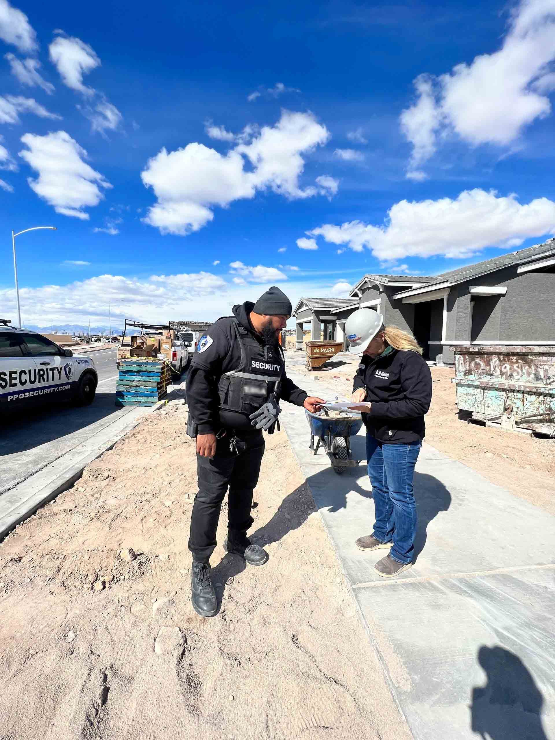 A man and a woman are standing on a sidewalk in front of a building under construction.