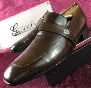A pair of brown gucci shoes sitting on top of a box