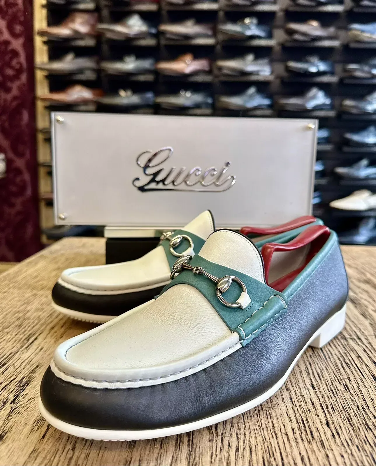 A pair of gucci loafers are sitting on a wooden table.