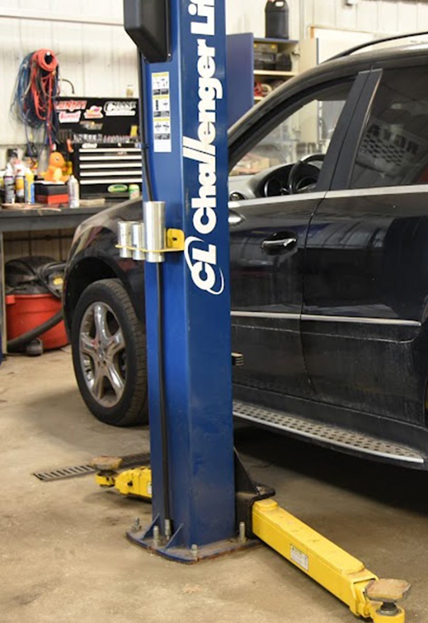 A black SUV on a Challenger lift | Shawn's Auto Repair and Performance