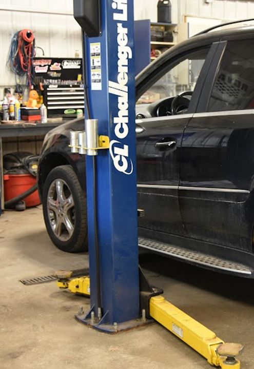 A black SUV on a Challenger lift | Shawn's Auto Repair and Performance