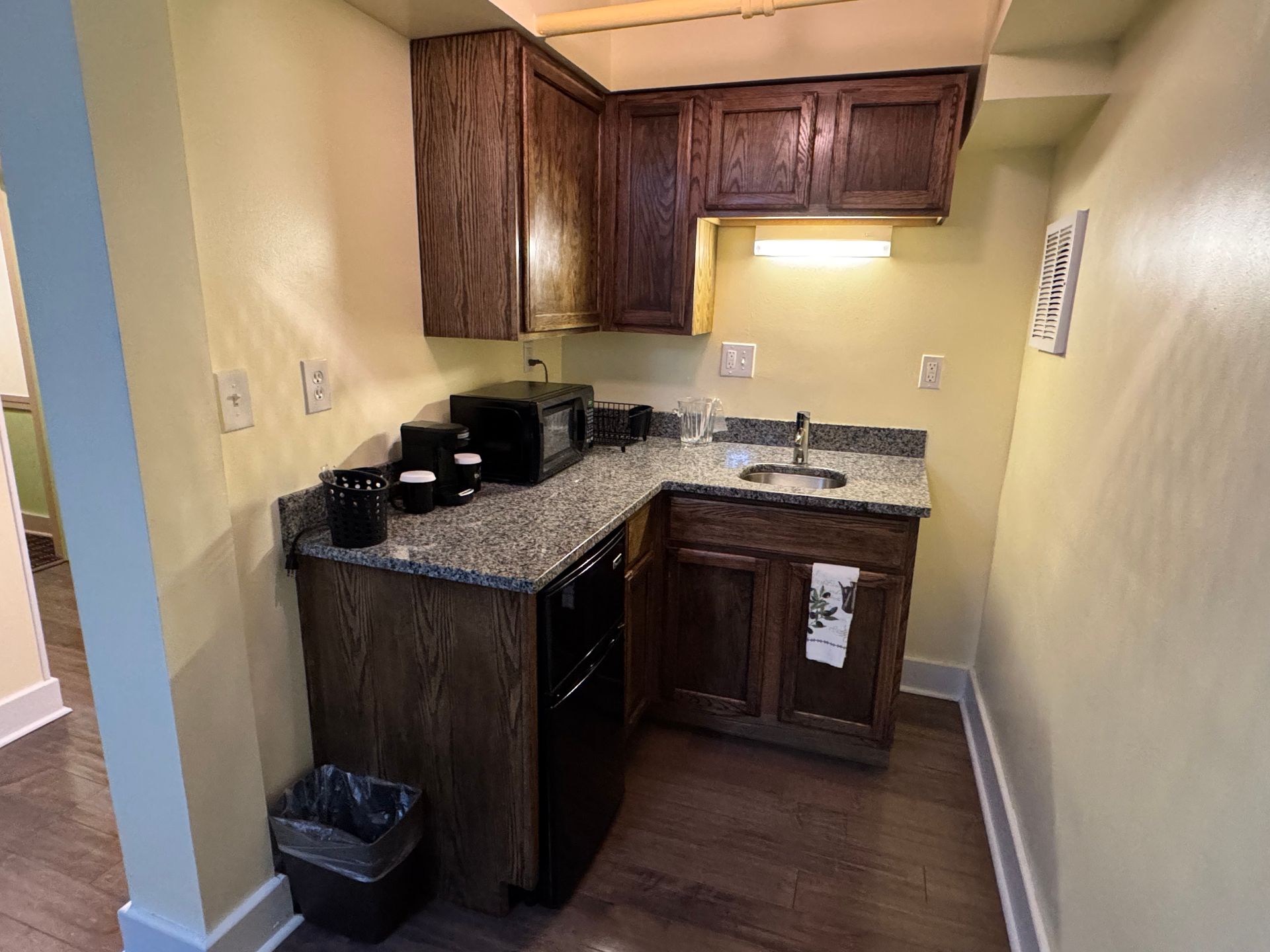 A small kitchen with a sink , stove , microwave , and dishwasher.