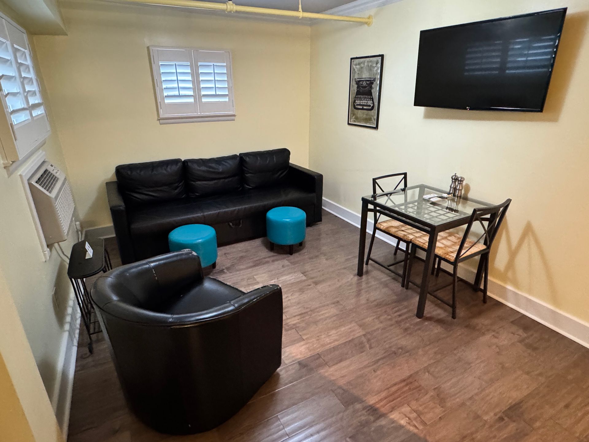 A living room with a couch , chair , table and television.