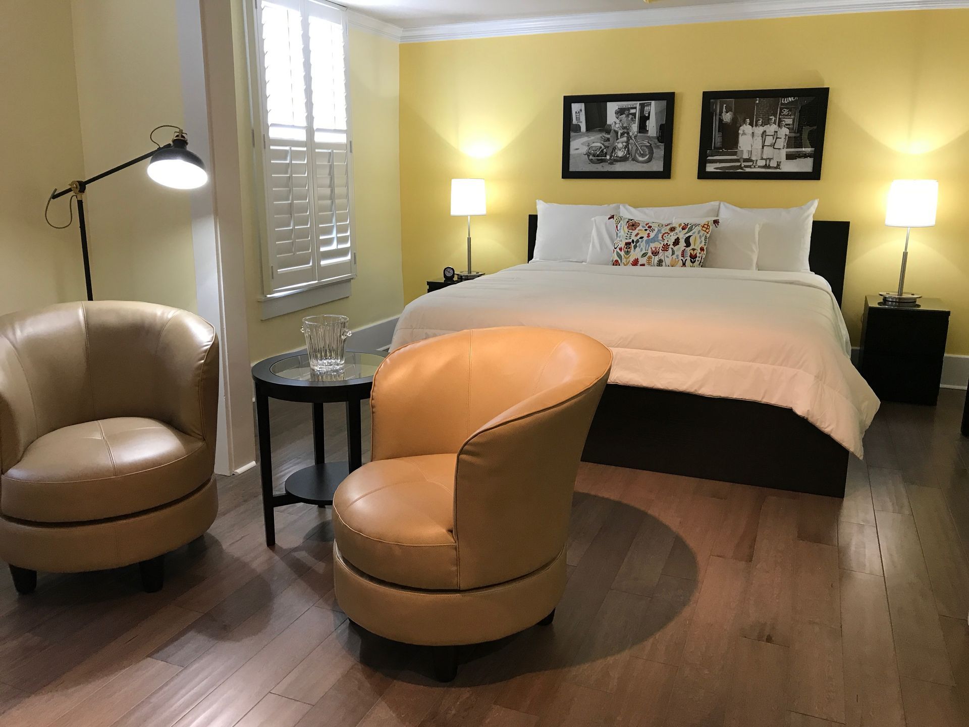 A bedroom with a large bed and two chairs