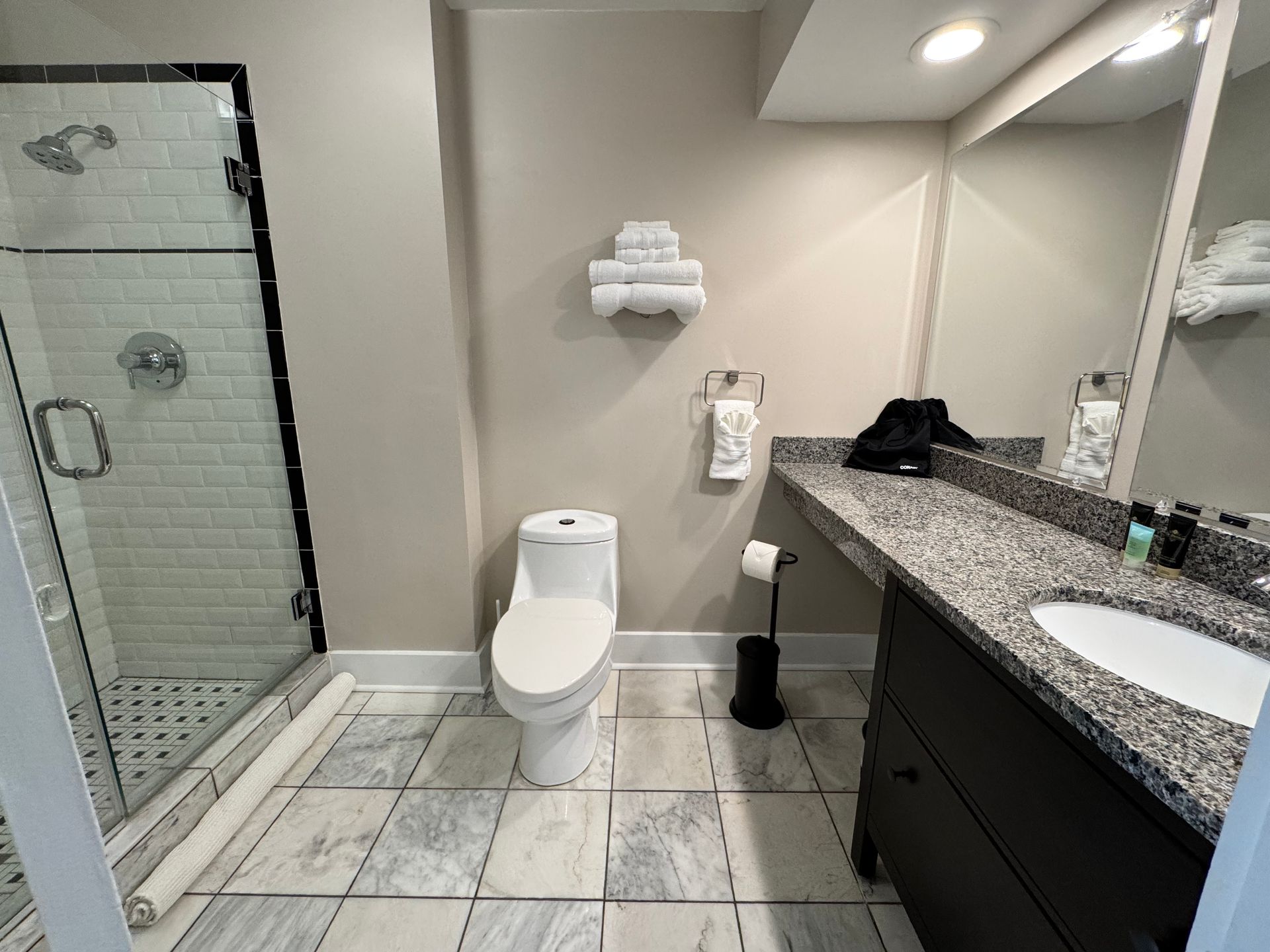 A bathroom with a toilet , sink and shower.