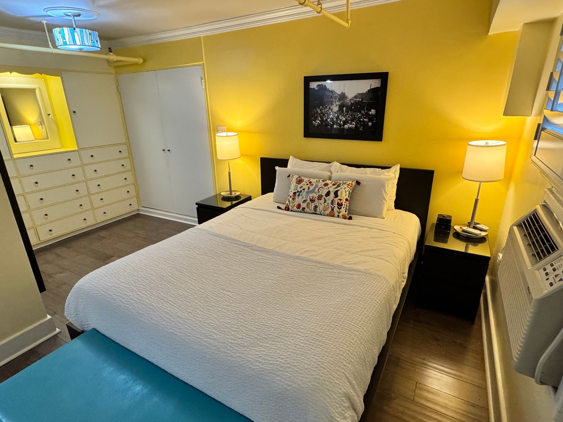 A hotel room with a bed and a picture on the wall