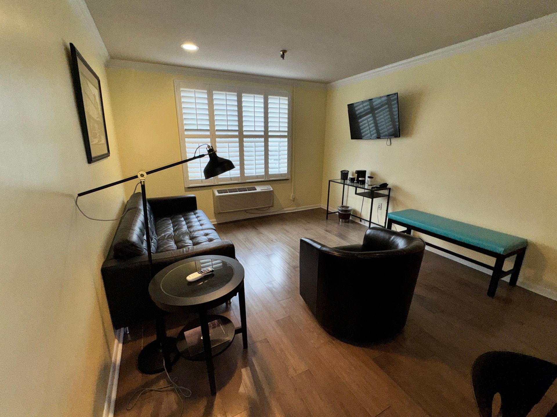 A living room with a couch , chair , table and television