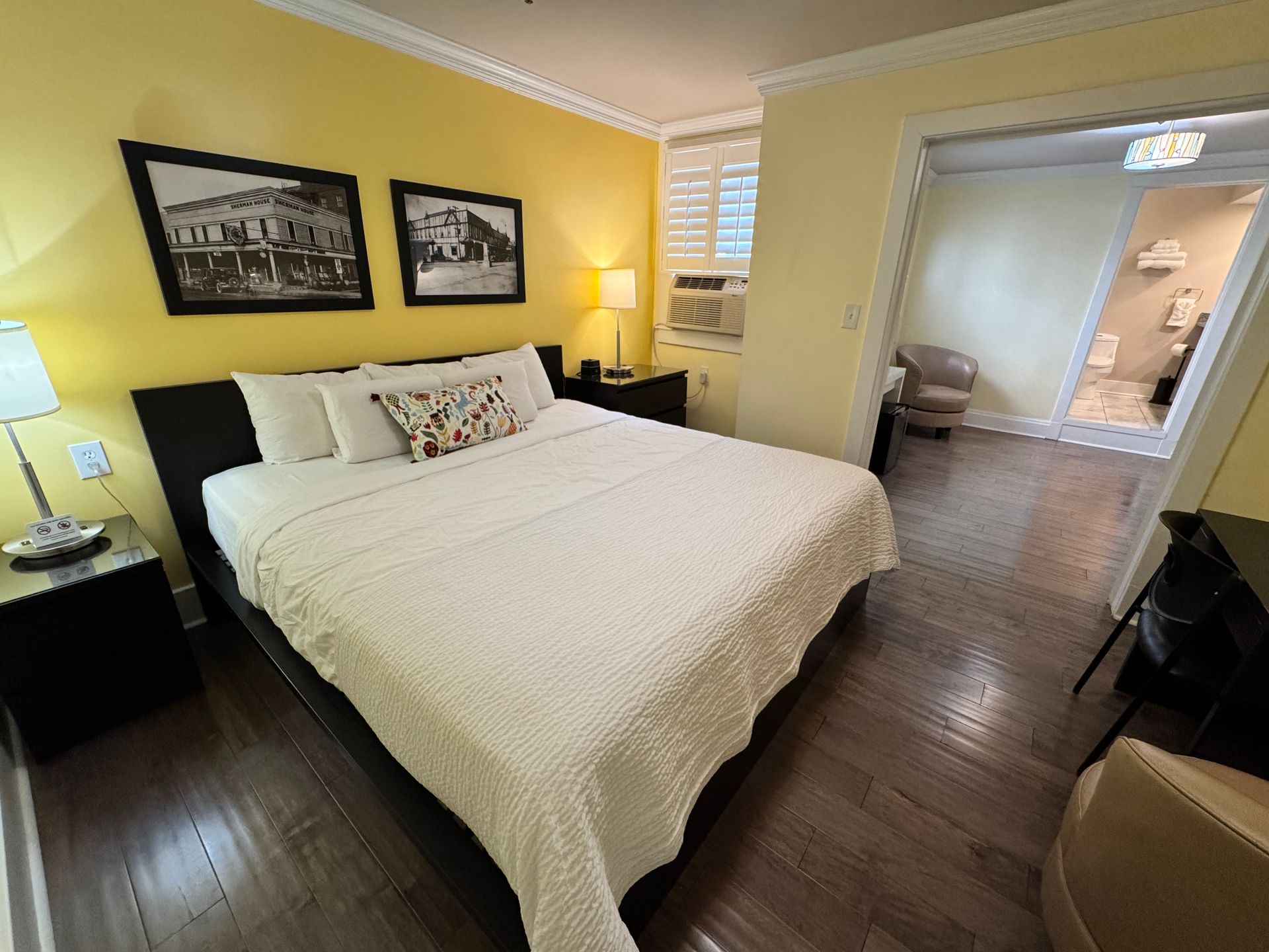 A bedroom with a king size bed and two pictures on the wall
