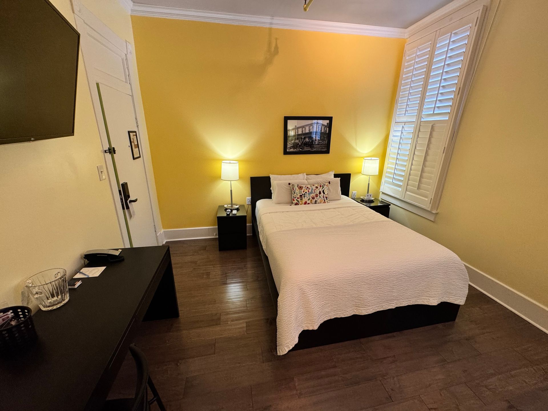 A hotel room with a bed and a desk