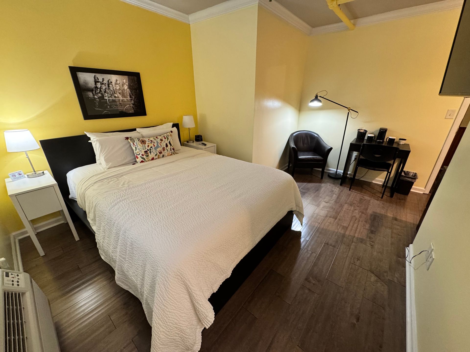 A bedroom with a king size bed and yellow walls