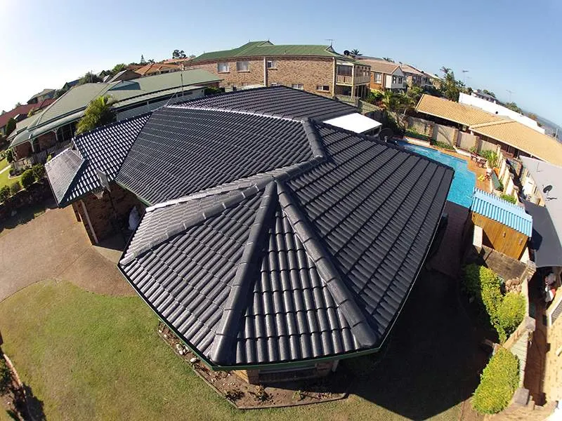 An aerial view of a house with a black tiled roof