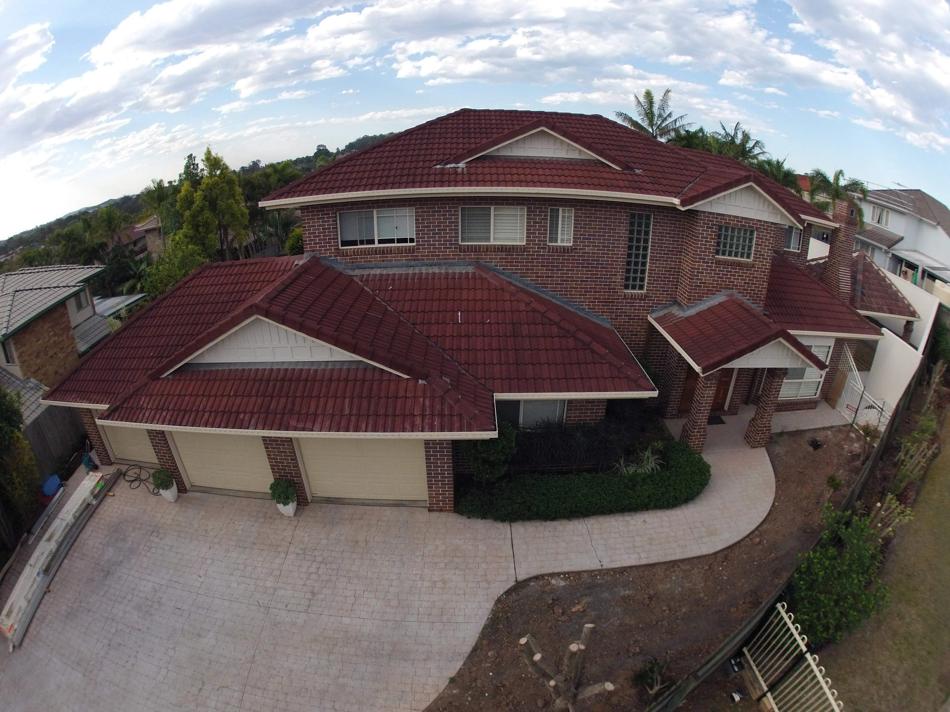 An aerial view of a large house with a red tile roof