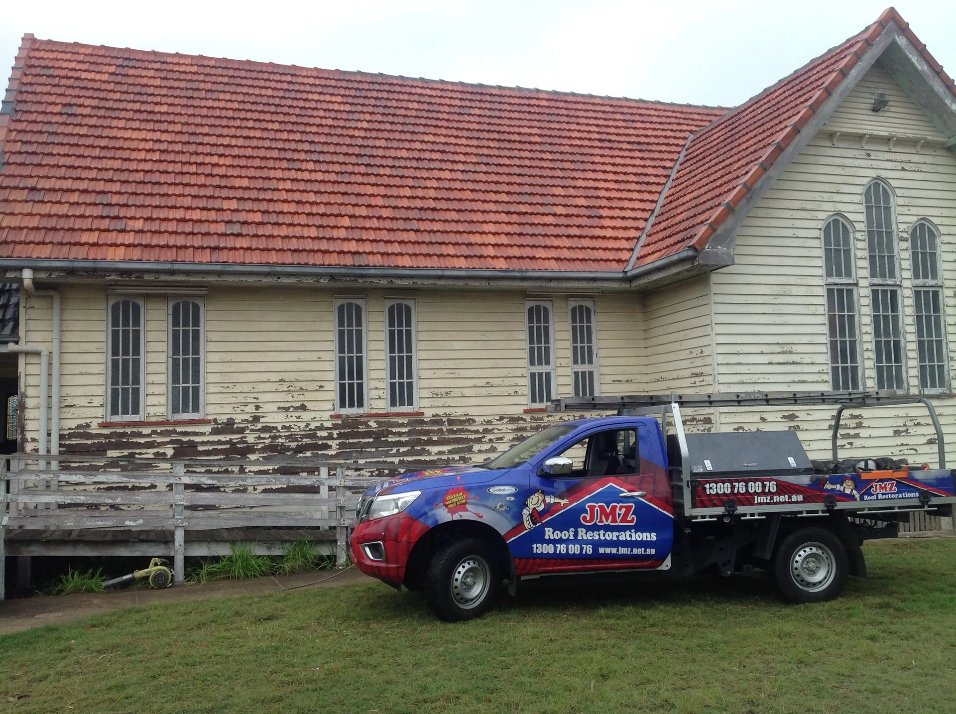 A truck is parked in front of a house with a red tile roof