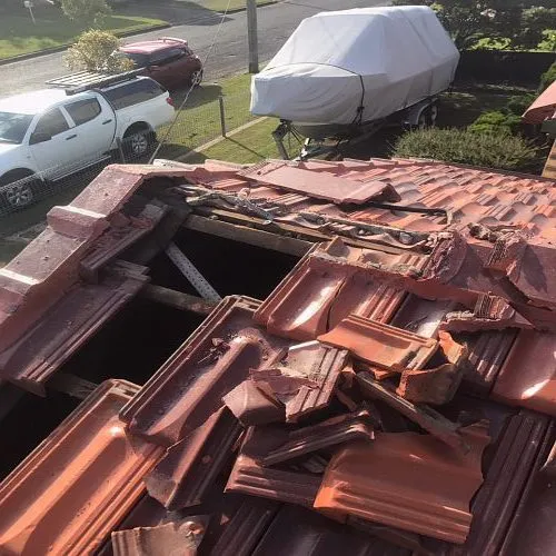 A roof with a lot of tiles on it and a boat in the background.
