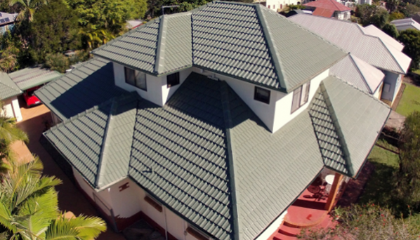 An aerial view of a house with a green tiled roof