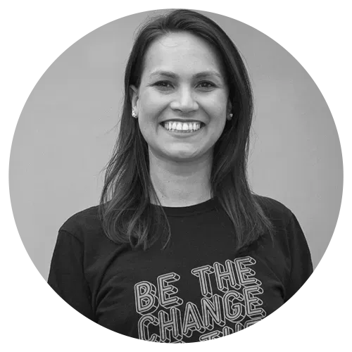 Mulher sorridente, vestindo uma camiseta preta com a frase 