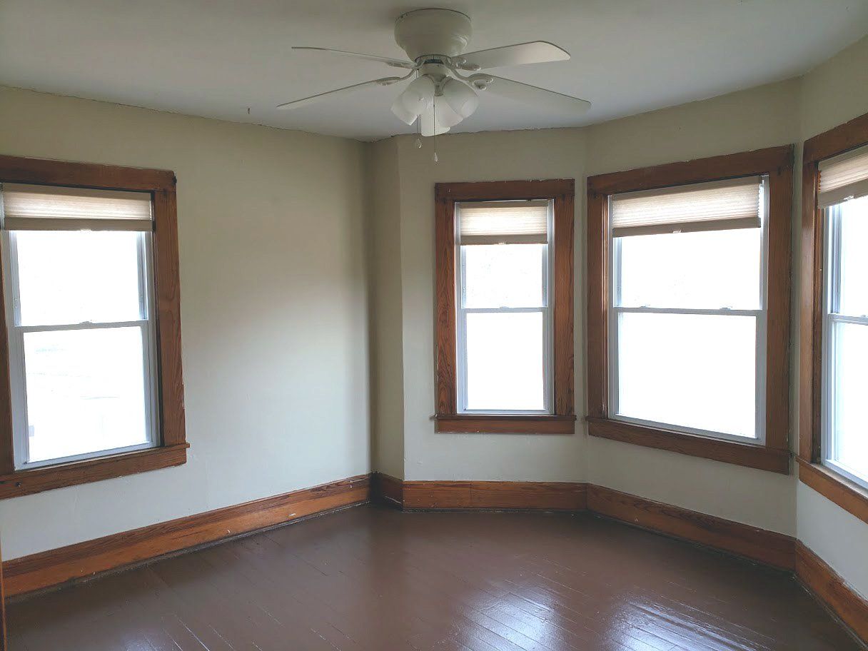 kent room rental with a ceiling fan and three windows