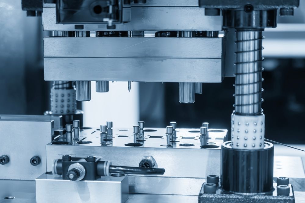 Close-up of industrial machinery, featuring metal components and springs, possibly for manufacturing.