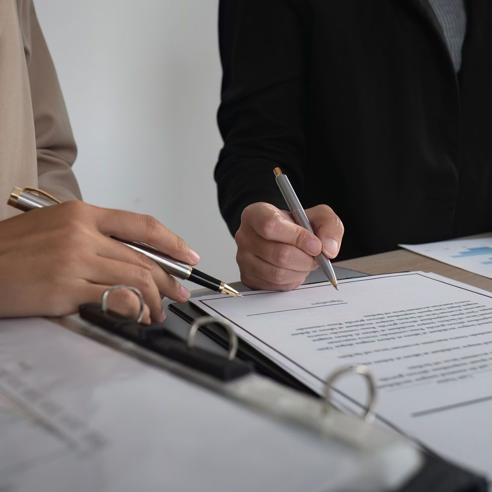 A person is writing on a piece of paper with a pen.