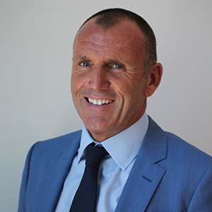 A man in a suit and tie is smiling for the camera.