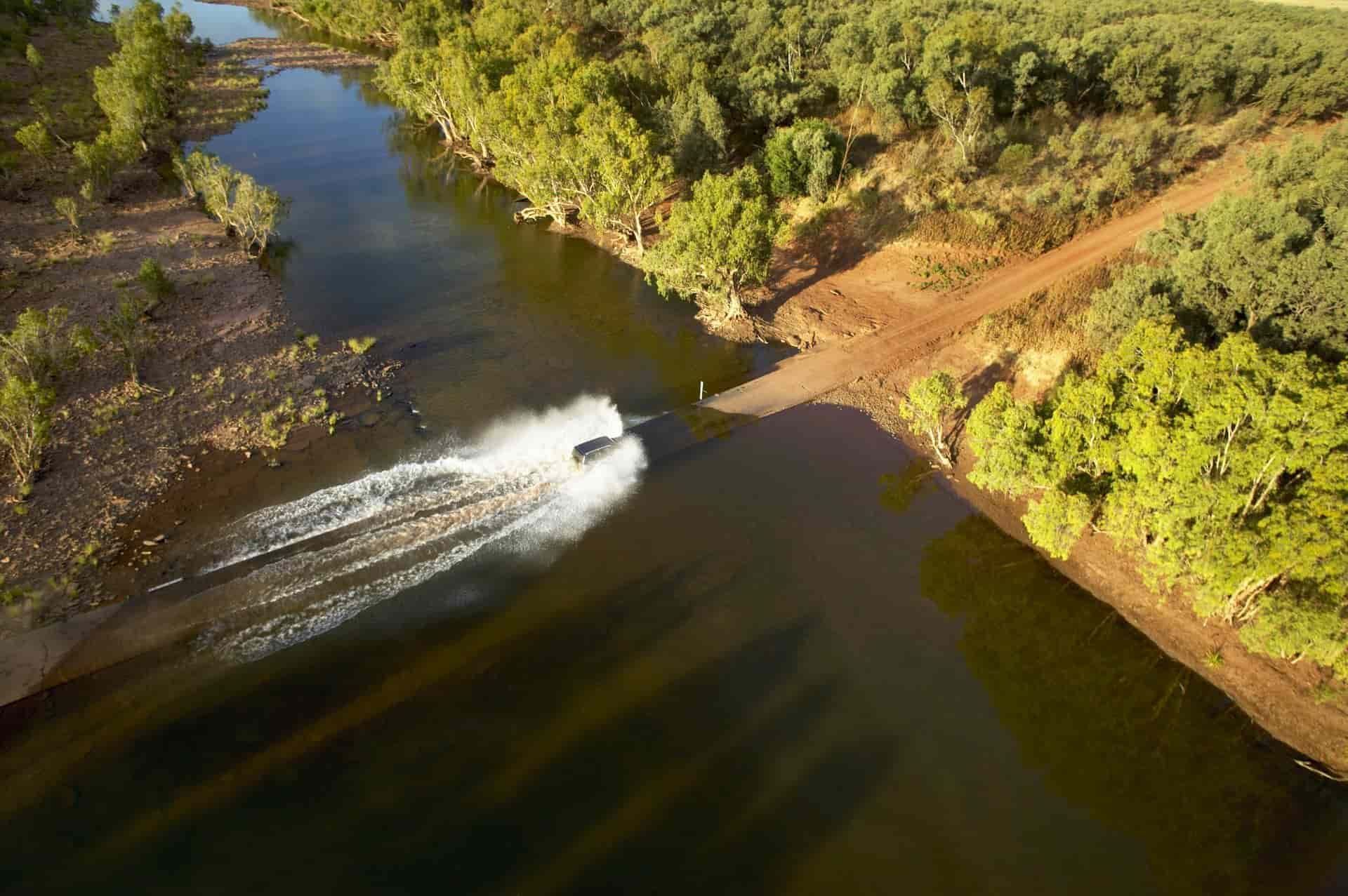 Aerial View of a Vehicle Crossing a Shallow River — NT Driver Guide - Escorted Touring & Transfers in Darwin City, NT