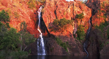 A Waterfall is Surrounded by Trees and Rocks — NT Driver Guide - Escorted Tours & Transfers in Darwin City, NT