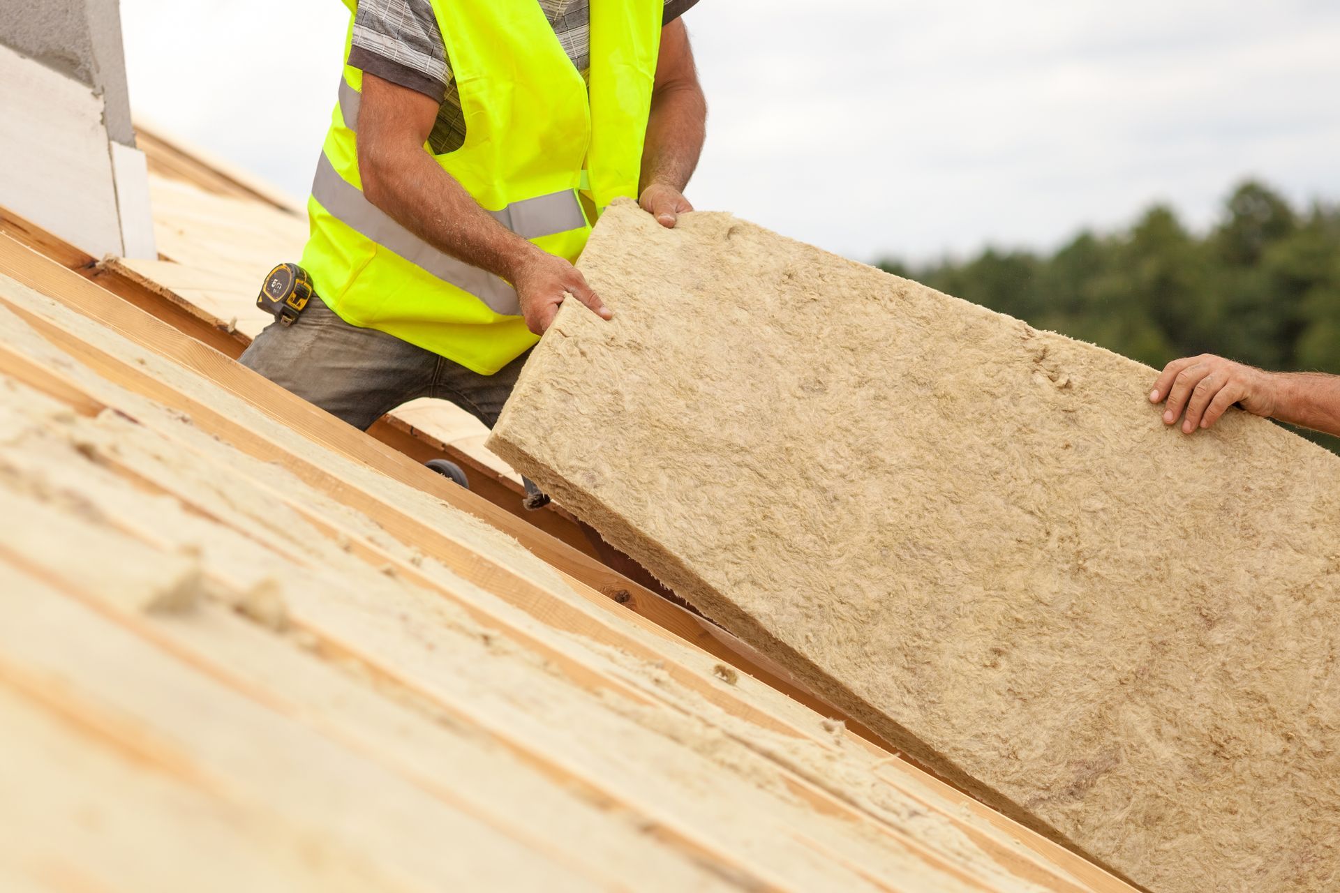 A worker is installing roof insulation material.