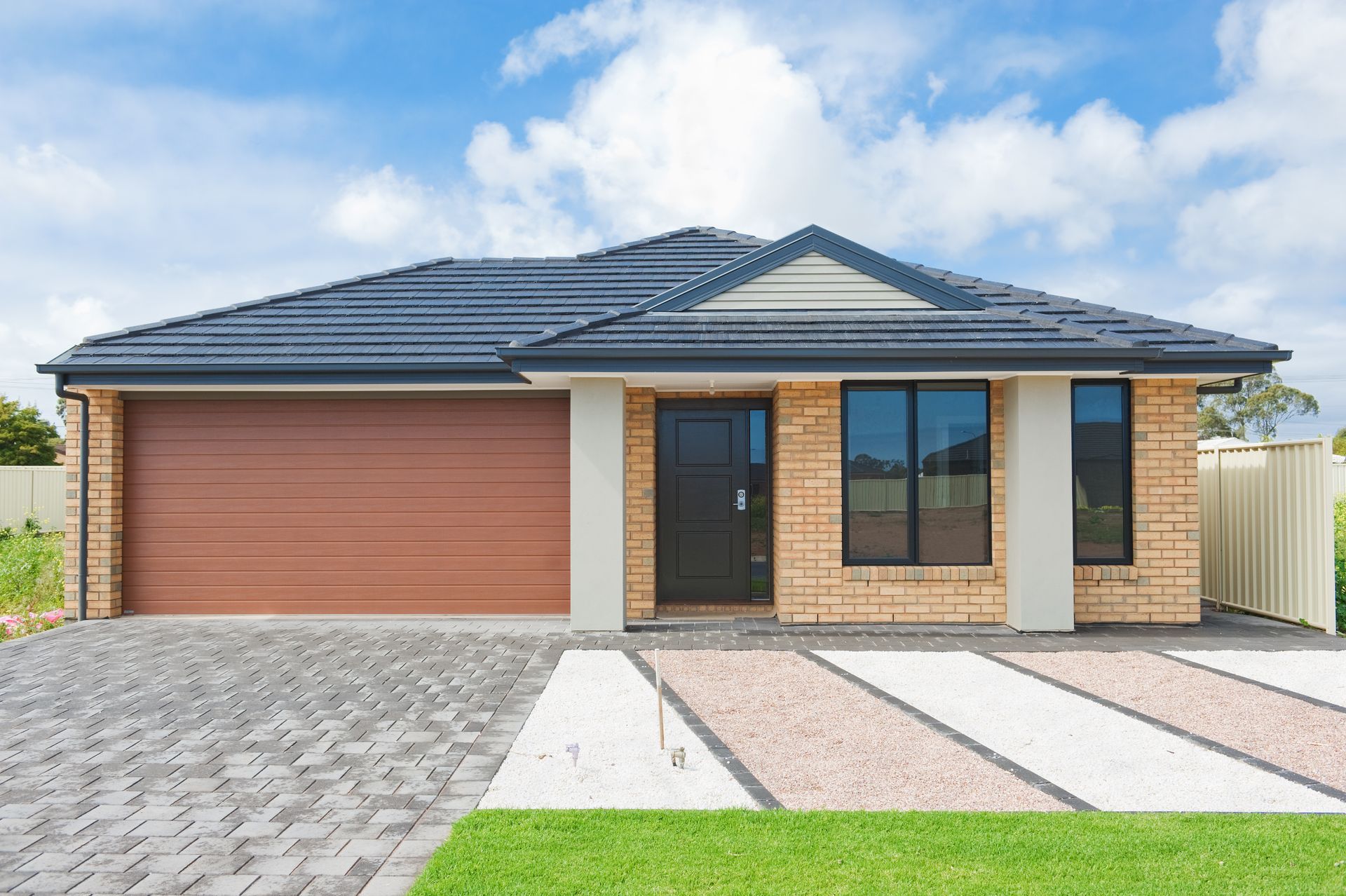View of a house with a new roof against a blue sky.