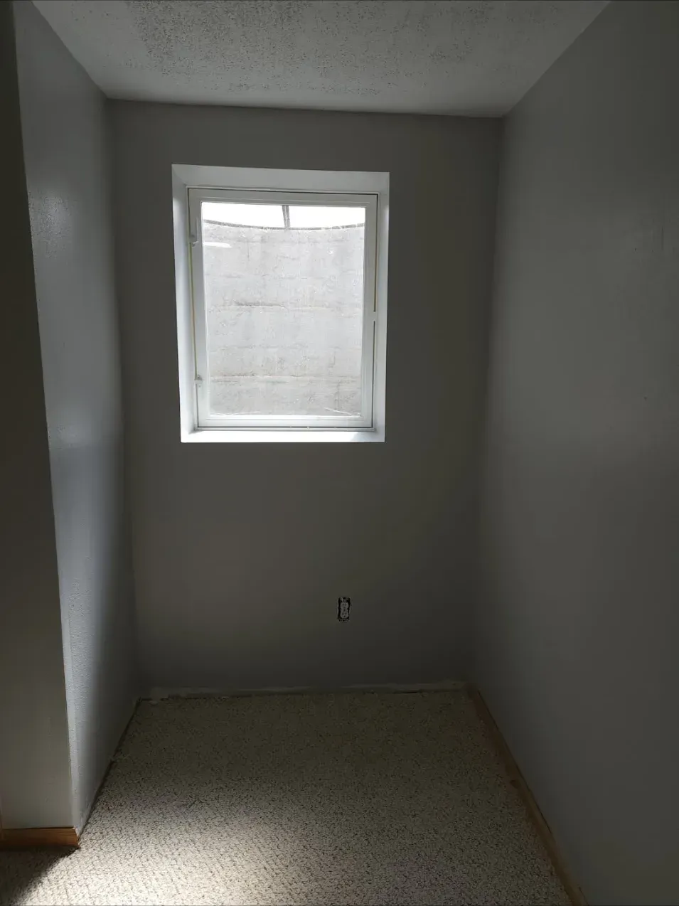 After finishing: smooth, evenly painted wall around the egress window with new carpet installed