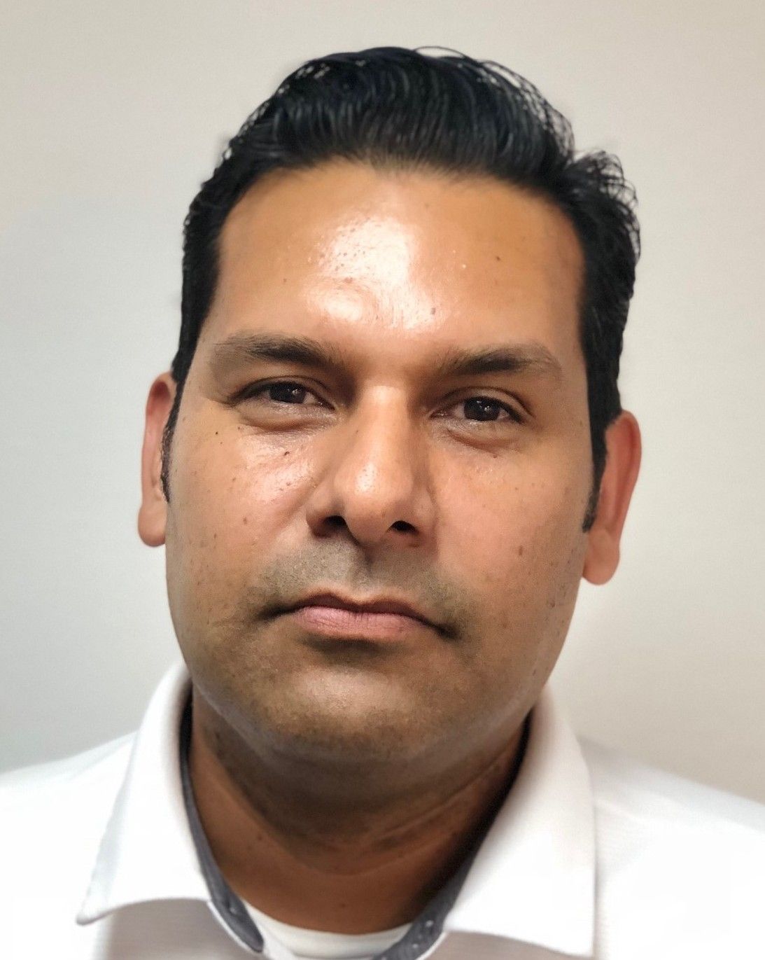 Portrait of a man in a white shirt against a plain light background